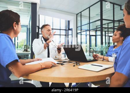 Facilitating their weekly meetings. a team of doctors having a meeting in a hospital. Stock Photo