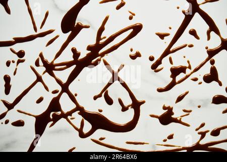 Salted Caramel sauce splashes on white marble background. A tabletop stained with caramel. Top view food photo.  Stock Photo