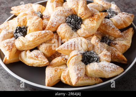 Finnish christmas time Joulutorttu puff pastries with dried plum marmalade close-up in a plate on a table. Horizontal Stock Photo