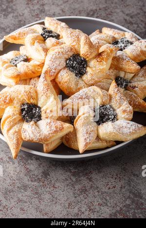 Joulutorttu Tahtitorttu Finnish Pinwheel Shaped Christmas Tarts close-up in a plate on a table. Vertical Stock Photo