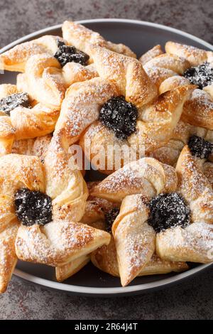 Finnish star-shaped joulutorttu christmas cake with dried marmalade close-up in a plate on a table. Vertical Stock Photo