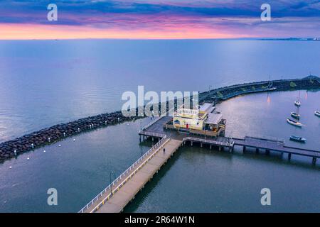 Aerial view a pavilion on a pier inside a breakwater with a coloured sunset sky in the distance at Sandringham in Melbourne, Victoria, Australia. Stock Photo