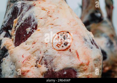 Carcasses of bovines in the cutting room of Seleviandes in Saint-Remy (central-eastern France). Close-up shot of a stamp Stock Photo