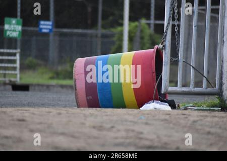 Buccoo, Tobago - June 4, 2023 - A rainbow colored bucket attached to a gate. Stock Photo
