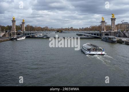 The sightseeing tour boat approaching Pont Alexandre III bridge in Paris, France. March 25, 2023. Stock Photo