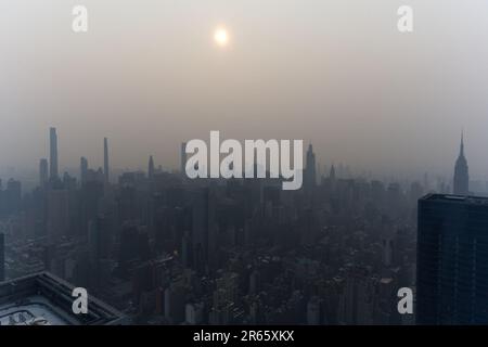 Manhattan, US, 07/06/2023, Manhattan skyline obscured by haze from Canadian wildfires, imparting a distinct atmosphere. Stock Photo