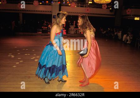 Two young debs discuss their deb’s delight at the Rose Ball held at the Dorchester Hotel in Park Lane. One of the remaining vestiges of the traditional London Season; where daughters of the British aristocracy were launched into London society.  The Ball is in aid of the Alexandra Rose Day charity, named after Queen Alexandra Consort of Edward VII. Mayfair, London, England May 1986. 1980s UK HOMER SYKES Stock Photo