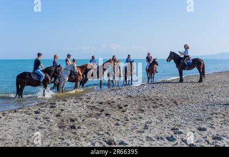 Policoro, Italy - 7 May 2023: People riding horses in a Policoro beach, Basilicata, southern Italy. Stock Photo