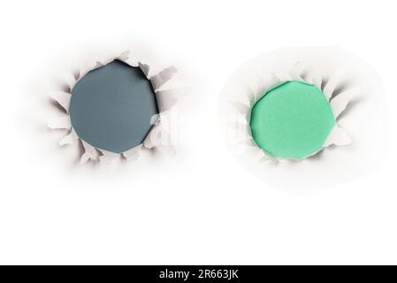 A hole in a white paper on a blue background, copy space. Stock Photo