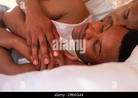 Close up serene, young gay male couple cuddling, sleeping in bed Stock Photo