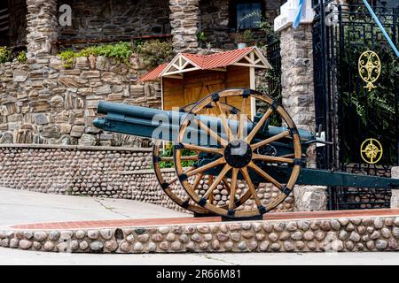 A black and brown antique cannon is prominently displayed in an outdoor museum setting Stock Photo