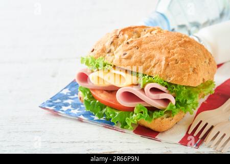 4th of July American Independence Day traditional picnic food. American sandwich or Burger on white, American flags and symbols of USA Patriotic picni Stock Photo