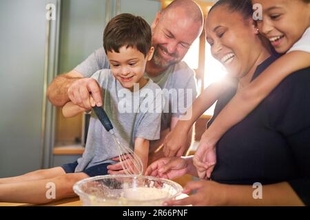 Happy family baking together in kitchen at home Stock Photo