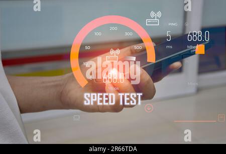 fast internet connection speedtest network bandwidth technology Man using high speed internet with smartphone and laptop computer. 5G quality, speed o Stock Photo