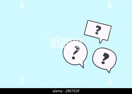 Speech bubbles with question marks on blue background Stock Photo