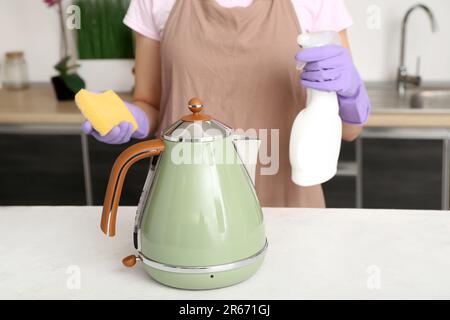 Woman in purple rubber gloves cleaning electric kettle with sponge Stock  Photo - Alamy