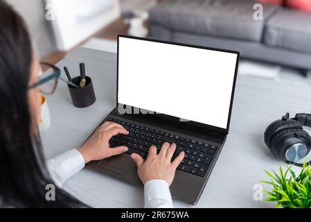 Woman work at home on laptop computer with isolated screen for web page presentation. Isolated screen in white. Living room in background Stock Photo