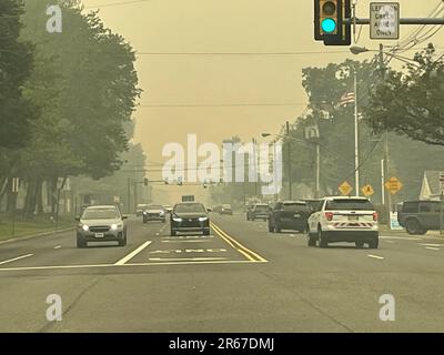 A hazy sky, caused by wildfires, creates low visibility and hazardous and unhealthy conditions in a suburban town Stock Photo