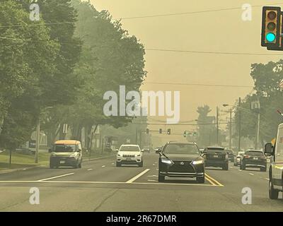 A hazy sky, caused by wildfires, creates low visibility and hazardous and unhealthy conditions in a suburban town Stock Photo