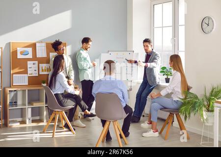 Male coach giving presentation for employees in office Stock Photo