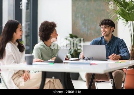 Smiling Colleagues Enjoying Teamwork Using Laptops During Business Conference Indoor Stock Photo