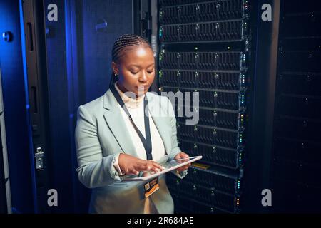 Let me test the speed. a young woman using a digital tablet while working in a server room. Stock Photo