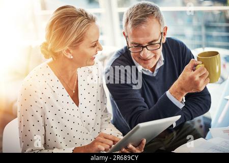 Using the smartest apps for smart budgeting. a mature couple using a digital tablet while going through paperwork at home. Stock Photo