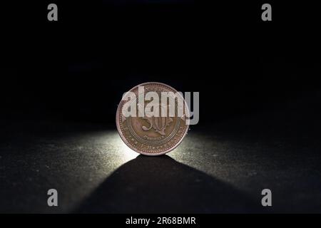 Picture of bosnian coin on a black background, with a focus on a coin of 50 feninga. The convertible mark is the currency of Bosnia and Herzegovina. I Stock Photo