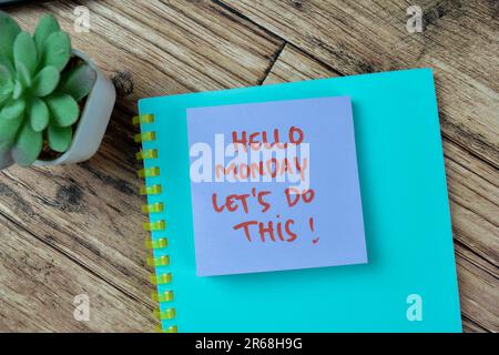 Concept of Hello Monday Let's Do This! write on sticky notes isolated on Wooden Table. Stock Photo