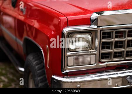 Izmir, Turkey - June 3, 2023: Close-up of the raindrop-covered headlight of a red 1980 Chevrolet Silverado truck at the IZKOD Classic Car Meet in Buca Stock Photo