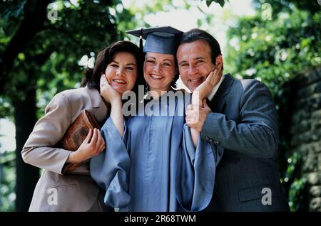 Portrait of a female Caucasian college graduate with her proud parents Stock Photo