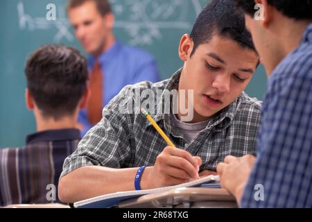 two male students collaborating on a project in class Stock Photo