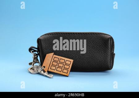 Leather case with keys on light blue background Stock Photo