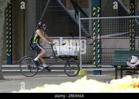 A bicycle courier from the Mail Call company at Queens Square near Hyde Park in Sydney. Stock Photo