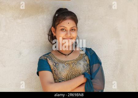 Portrait of a beautiful young teenage girl, Indian nationality. Against the background of the textural wall with copy space for text or word. Outdoors Stock Photo