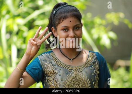 Indian Teenage Girl showing and pointing with finger number three while smiling confident and happy. Stock Photo