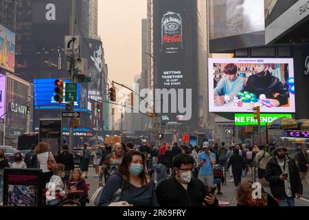 New York, New York, USA. 7th June, 2023. (NEW) Smoke From Canadian Wildfires Blows South Creating Hazy Conditions On Large Swath Of Eastern U.S. June 07, 2023, New York, New York, USA: Pedestrians wearing masks make their way around Times Square amid smoke from Canadian forest fires that blankets the skyline of New York City on June 7, 2023 in New York City. New York topped the list of most polluted major cities in the world on Tuesday night, as smoke from the fires continues to blanket the East Coast. The city issued an air quality advisory, urging all citizens to stay indoors. (Cred Stock Photo