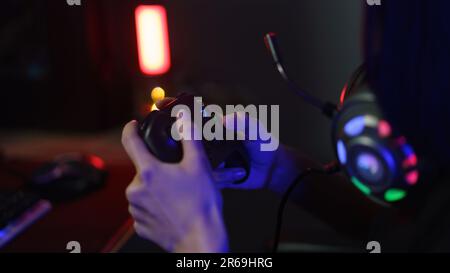 Female cyber hacker gamer using controller joystick to playing or streaming games on computer. Stock Photo