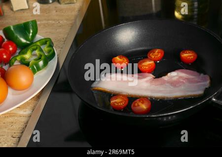 https://l450v.alamy.com/450v/2r69mt5/cooking-bacon-with-tomatoes-in-frying-pan-ingredients-for-breakfast-2r69mt5.jpg