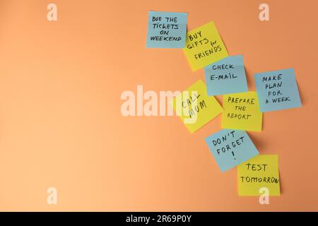 Many different reminder notes on pale orange background. Space for text Stock Photo