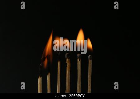 Line of burning matches on black background Stock Photo