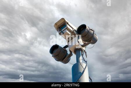 looking up at isolated CCTV security camera with infrared lights, big brother surveillance concept storm clouds Stock Photo