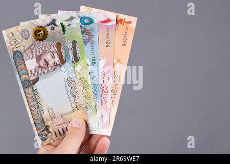 Bahraini money - dinar in the hand on a gray background Stock Photo