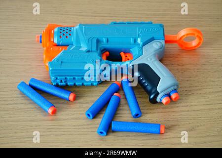 A blue Nerf gun with bullets on a wooden floor Stock Photo