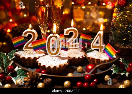Food tray with cupcakes new year candles wineglasses and rainbow flags decorations Stock Photo