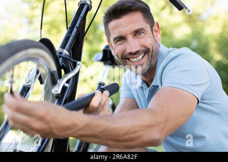 close up man inflating the wheel of a bicycle Stock Photo