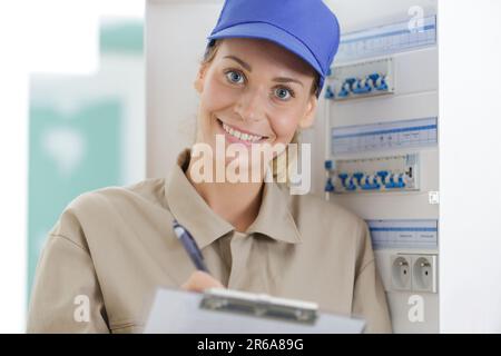 happy female technician electrical terminal box Stock Photo