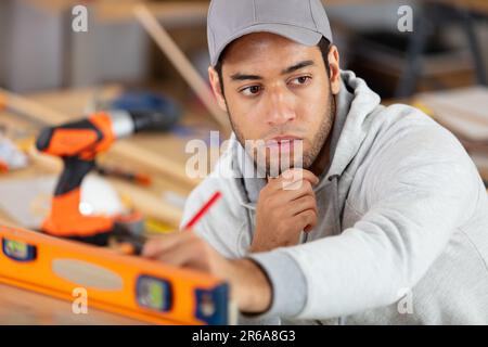 young handyman using a spirit level Stock Photo
