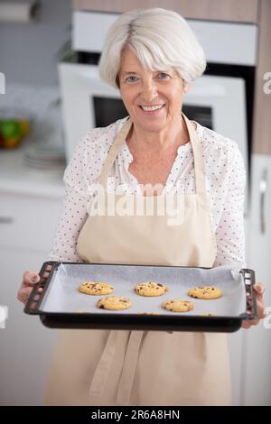 attractive senior woman is cooking on kitchen Stock Photo