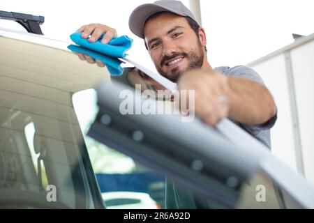 man worker polishing car on a car wash Stock Photo